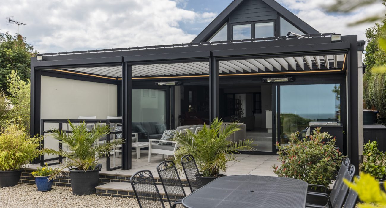 Dual Colour Bioclimatic Pergola with black aluminium frame and white rotating louvres installed on a modern UK home
